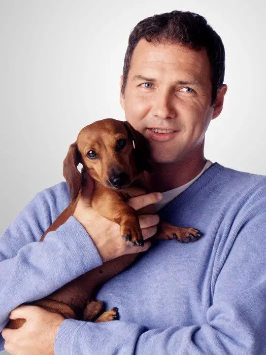 Norm Macdonald wit his Dachshund on his chest