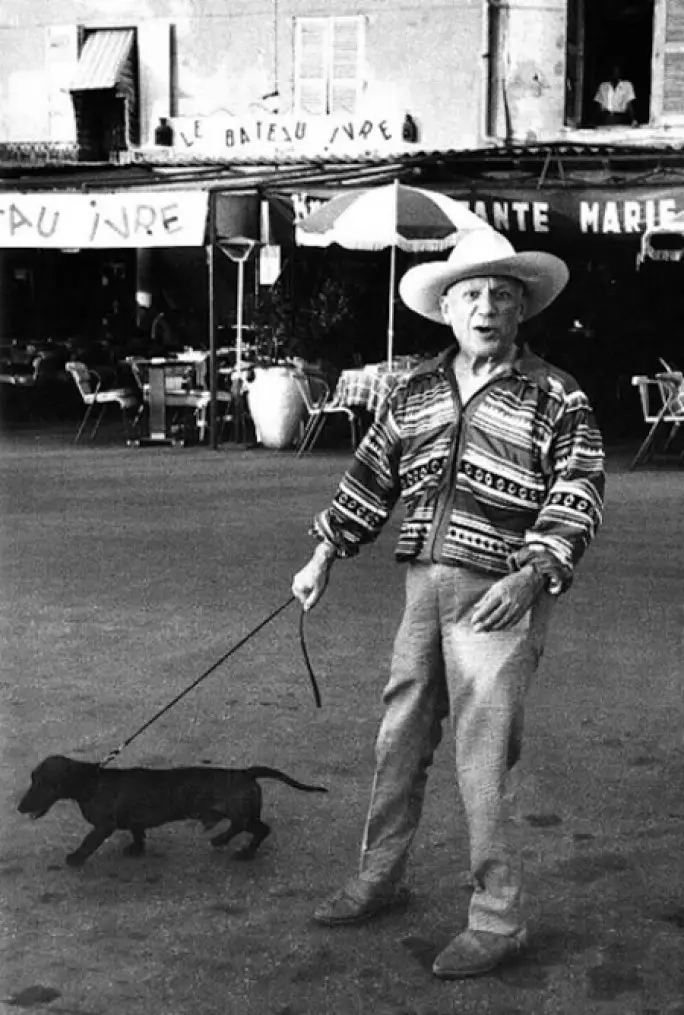 black and white photo of Picasso with his walking Dachshund