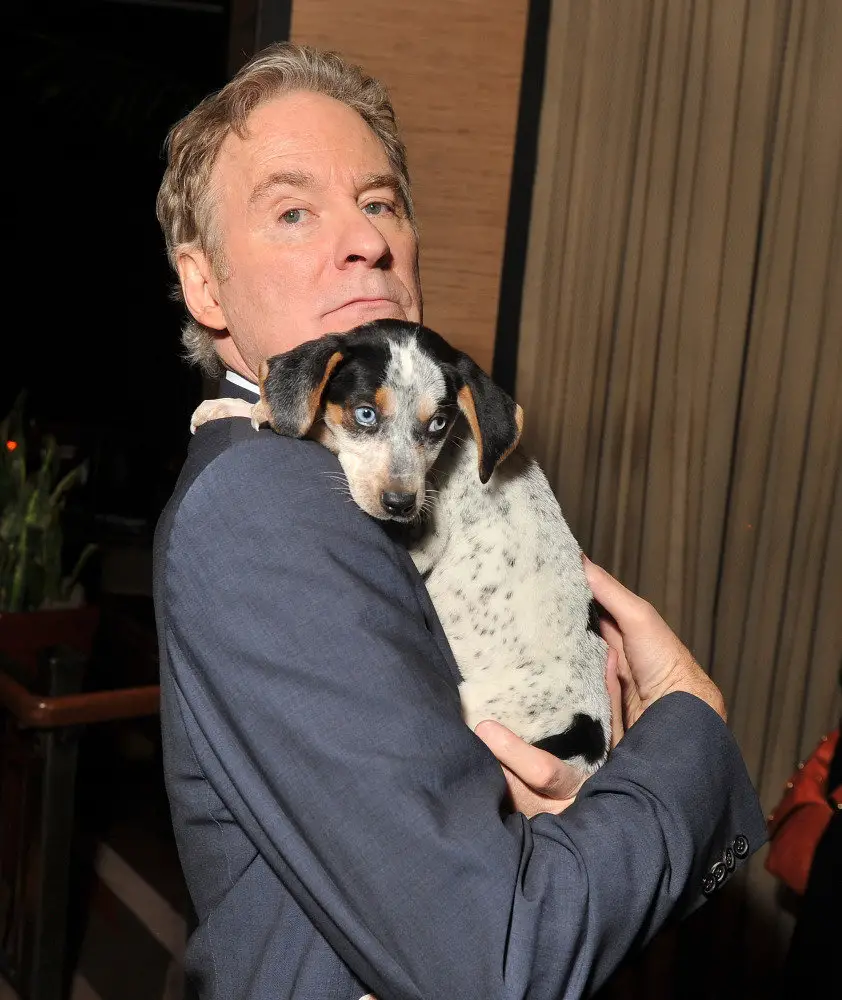 Kevin Kline carrying his Dachshund in his shoulder