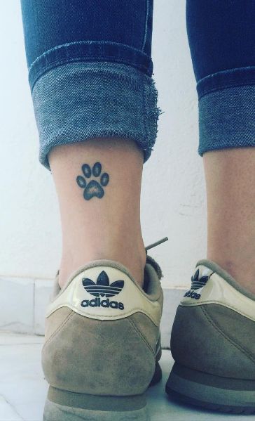 a paw print tattoo on the leg of the woman