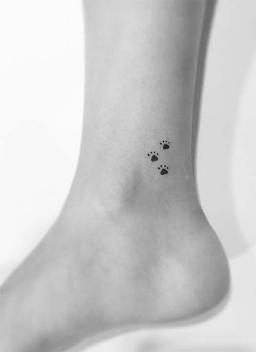 three small paw prints tattoo on the ankle