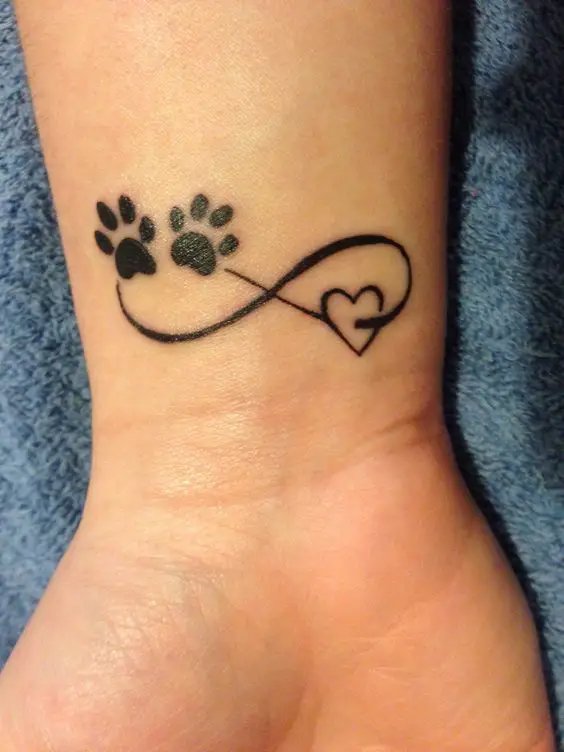 infinity sign with paw prints and heart tattoo on the wrist