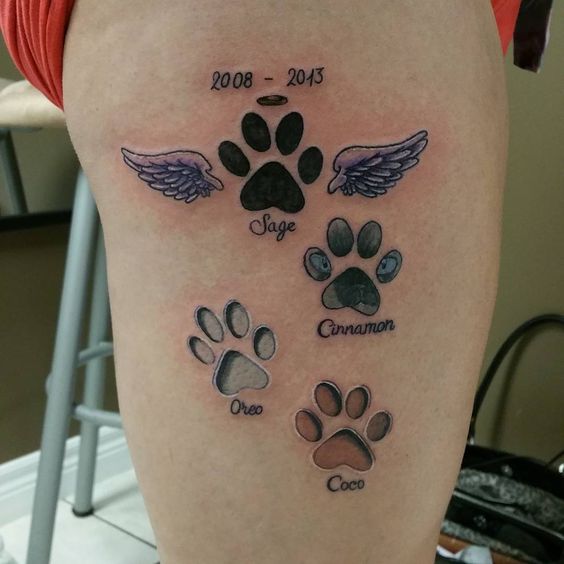 gour paw prints with the upper one has wings and date - 2008-2013 tattoo on the thigh of the woman