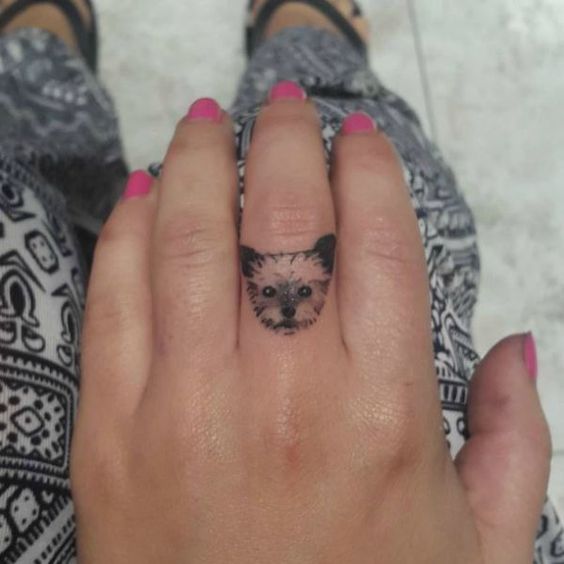 minimalist yorkie face on the ring finger of a woman