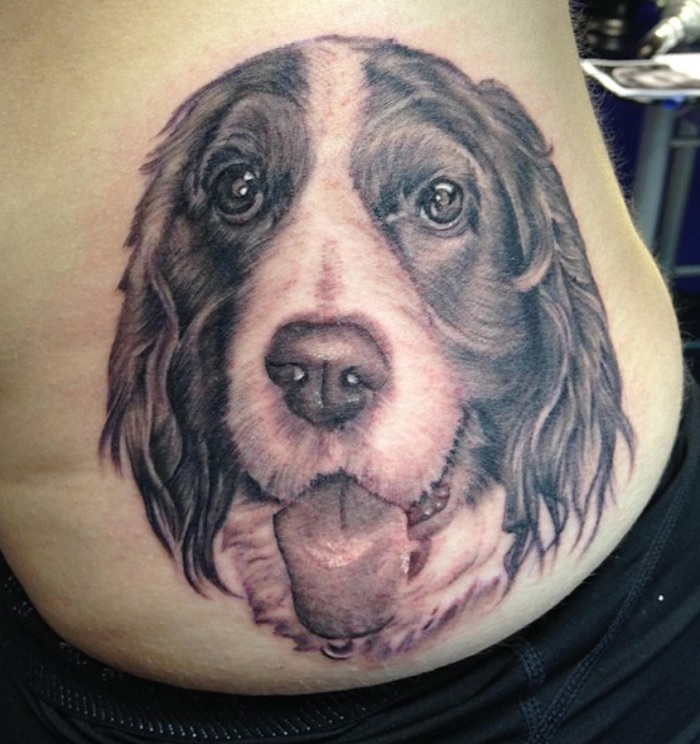 large tattoo face of Cocker Spaniel on the lower back