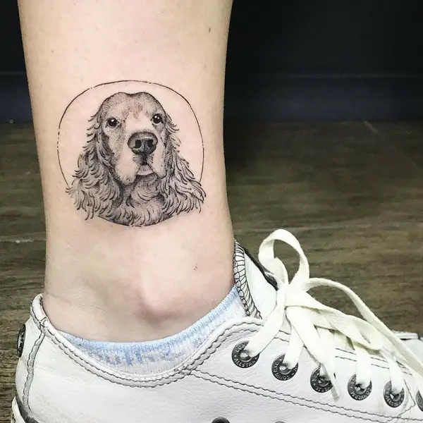 face of a Cocker Spaniel inside a circle Tattoo on the ankle