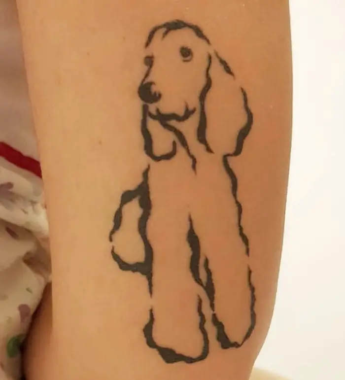 outline of sitting Cocker Spaniel Tattoo on the back of the arm