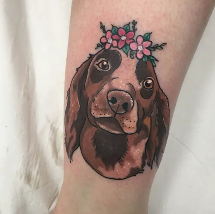 face of brown Cocker Spaniel wearing flowers crown Tattoo on the leg