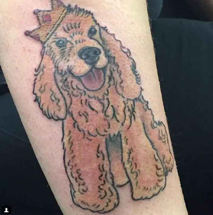 animated Cocker Spaniel wearing a crown Tattoo on the forearm