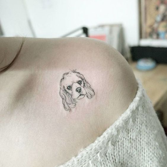 minimalist tattoo face of a Cocker Spaniel on the shoulder