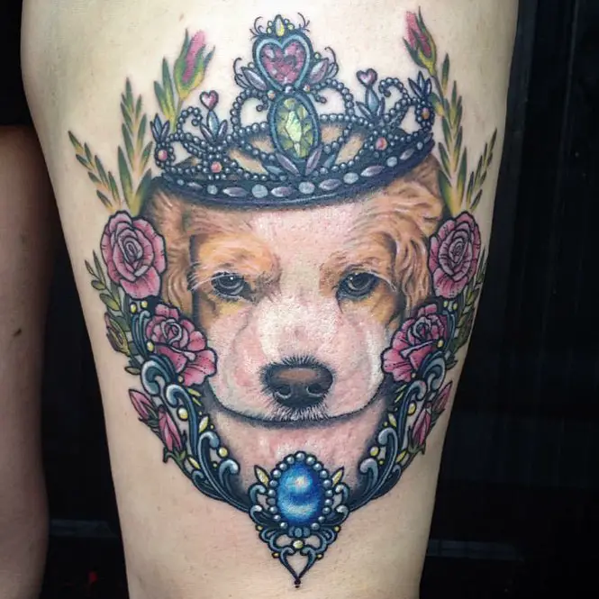 realistic face of a Cocker Spaniel wearing a crown and flowers and leaves around tattoo on the leg