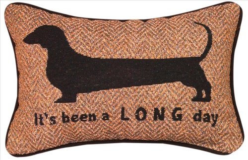 A throw pillow with embroidered dachshund and message - It's ben a long day