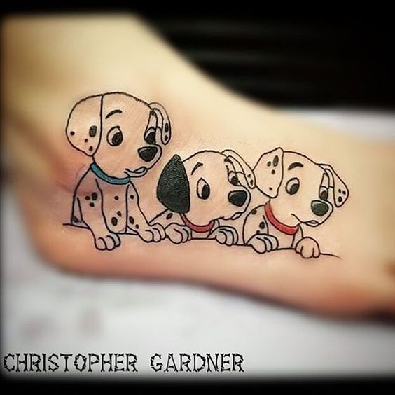 three Dalmatian cartoon character puppies tattoo on foot