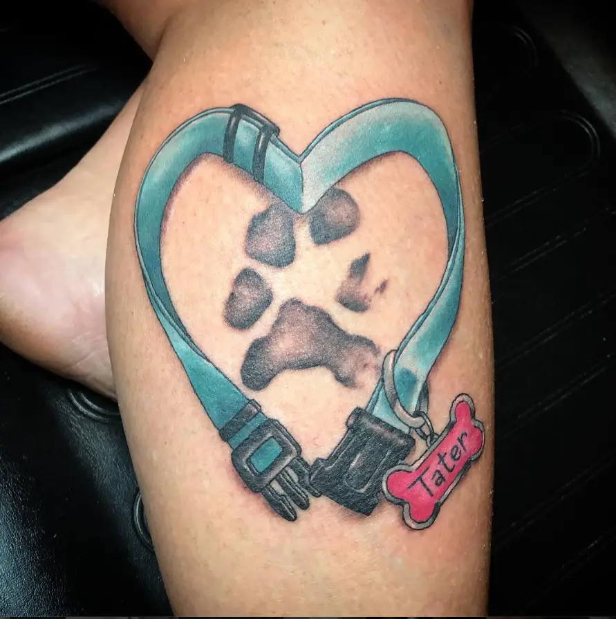blue heart shaped collar with paw print inside tattoo on the leg
