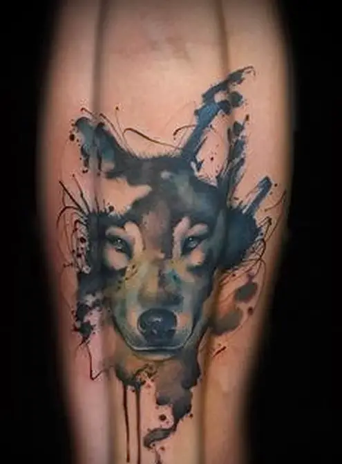 face of a Husky in watercolor design tattoo on the leg of a man