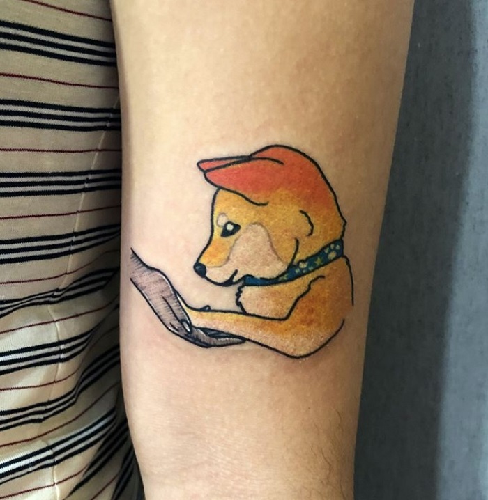 animated Shiba Inu putting its paw on hand tattoo on the biceps