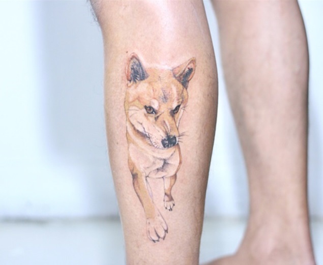 a walking Shiba Inu dog tattoo on the leg