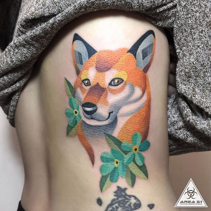 face of a Shiba Inu with flowers and leaves colored tattoo on the side of the body