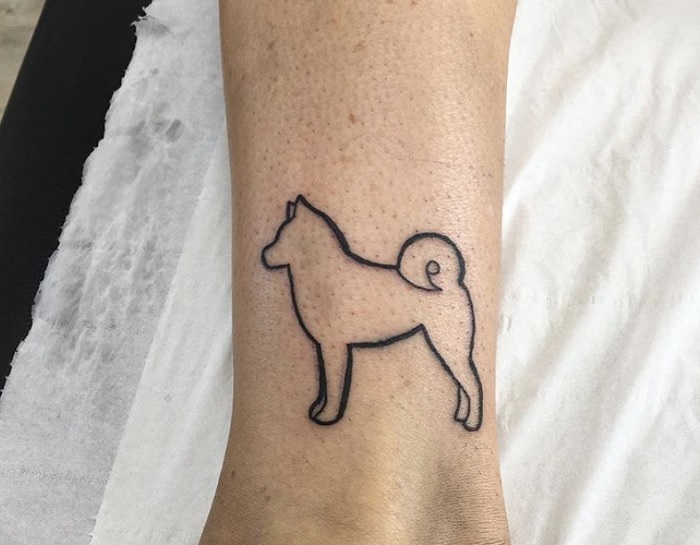 outline of Shiba Inu dog tattoo on the ankle