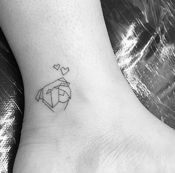 geometric face of dog tattoo on the ankle