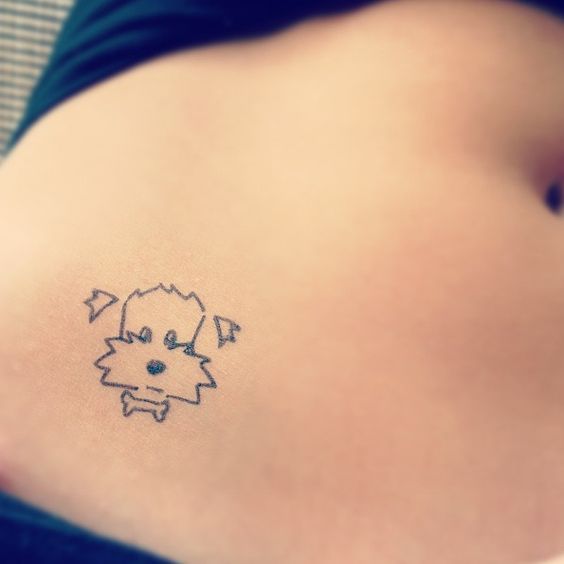 outline face of dog tattoo on the tummy