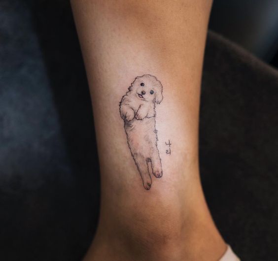 small dog lying on its back tattoo on ankle