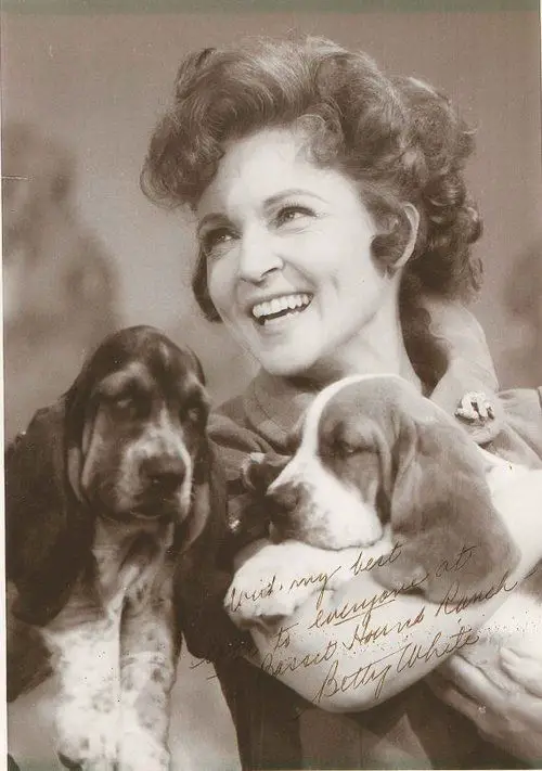 Betty White holding its two Basset Hounds