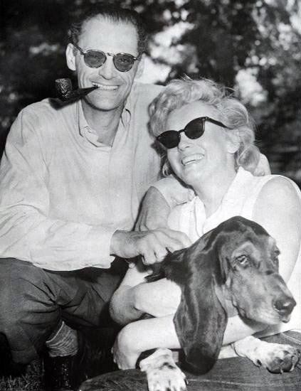 black and white photo of Marilyn Monroe and Arthur Miller with their basset hound dog