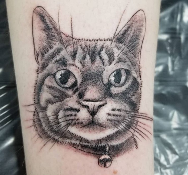 A black and gray face of a cat tattoo