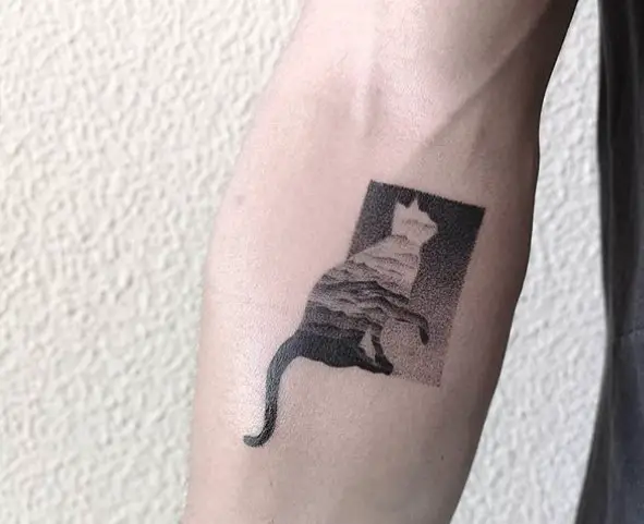 a black and gray cat in a rectangle shape tattoo on the forearm
