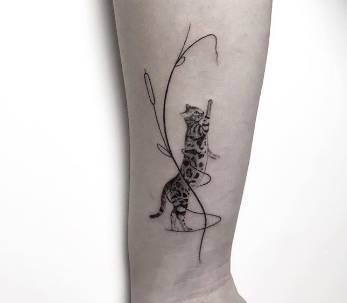 A Black and White Cat tattoo on the forearm
