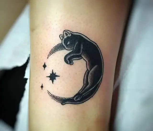 sleeping black cat n a crescent moon tattoo on wrist