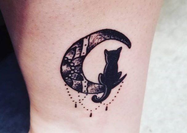 black cat sitting on a crescent moon