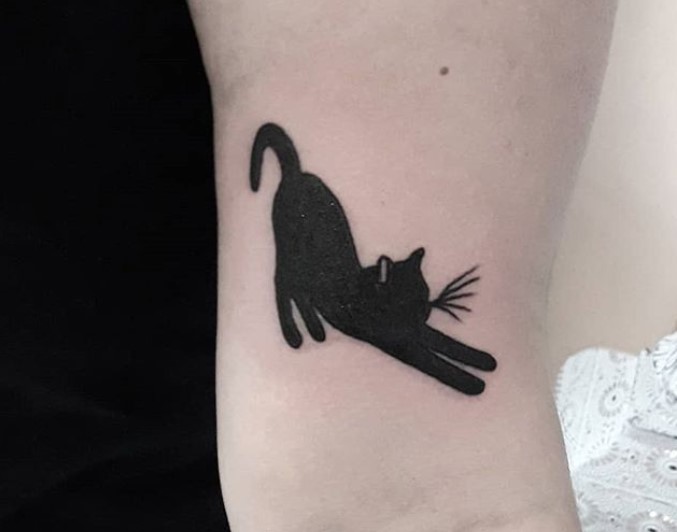 stretching black cat tattoo on wrist