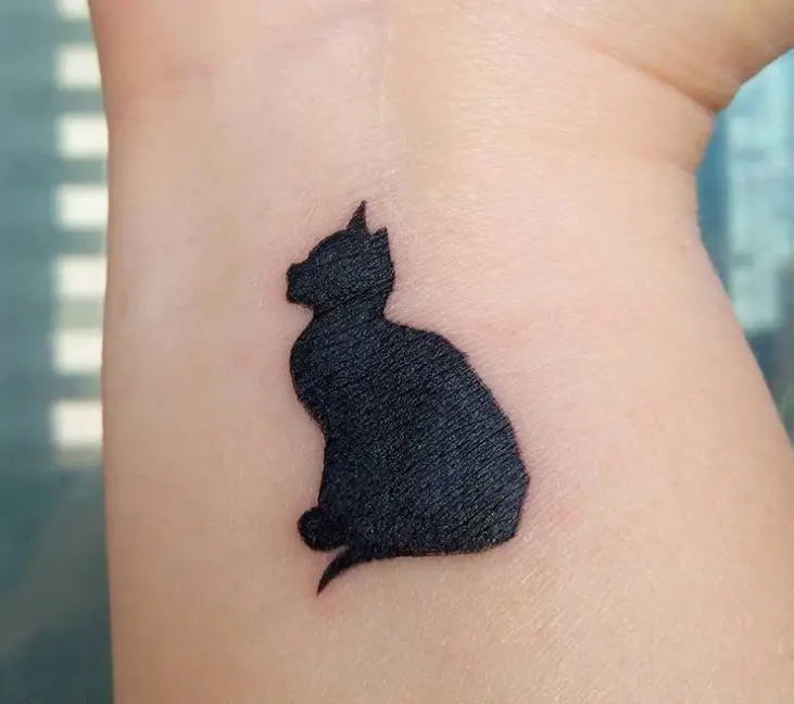 sitting black cat tattoo on wrist