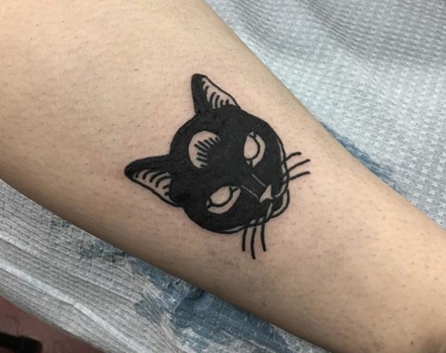 face of black cat tattoo on wrist