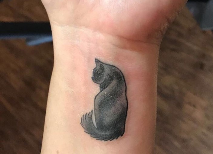 back of black cat tattoo on wirst