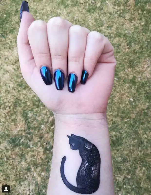 black cat with galaxy on its back tattoo on wrist