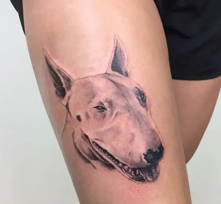 black and gray side view face of a smiling Bull Terrier tattoo on thighs