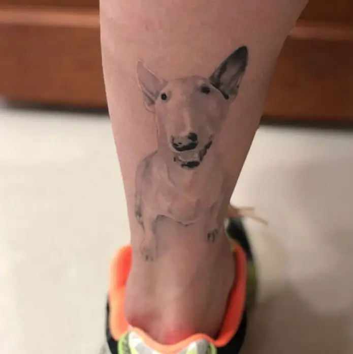 soft minimalist white and black Bull Terrier in sitting position tattoo on the leg
