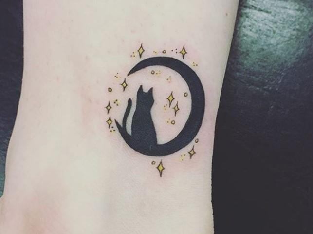 black cat in a black crescent moon with yellow stars tattoo