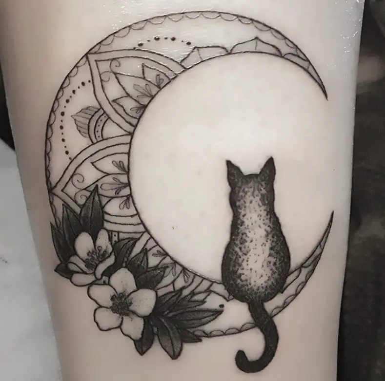 cat sitting on a crescent moon with flowers and mandala design