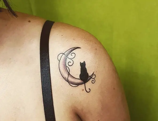 cat sitting on the crescent moon tattoo on the shoulder