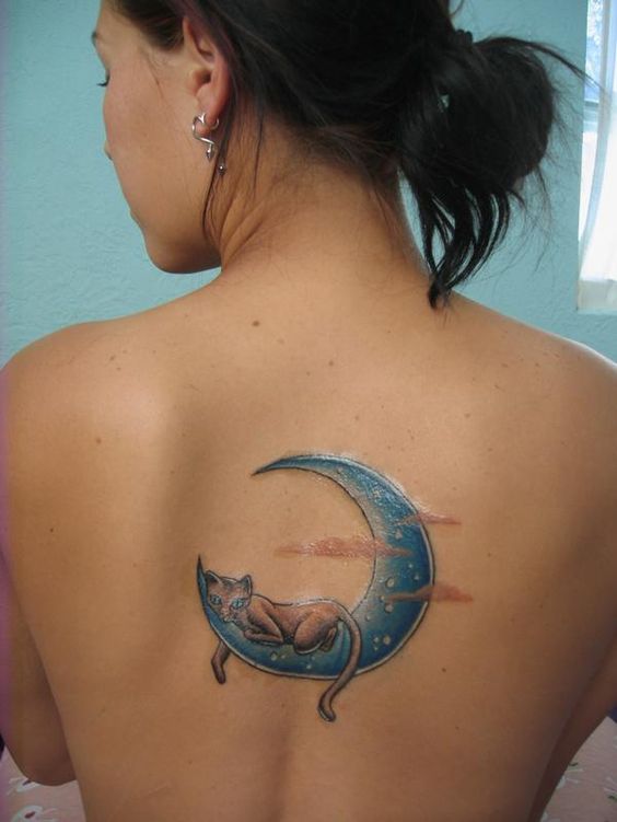 cat on a blue crescent moon tattoo on the back