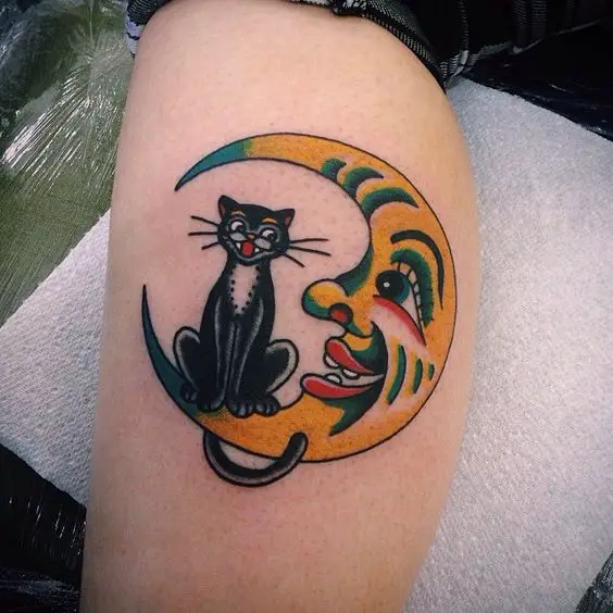 clown crescent moon and cat smiling with each other tattoo on the leg
