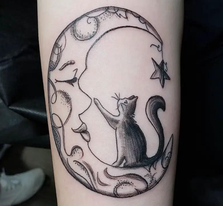 a cat touching the nose of a crescent moon face tattoo on the forearm
