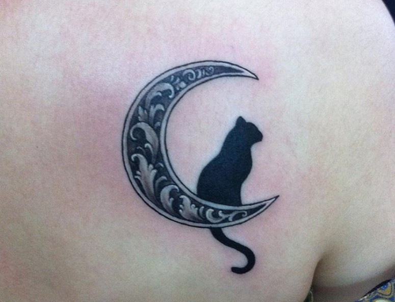 black cat sitting on the crescent mood with a mandala design tattoo on the back