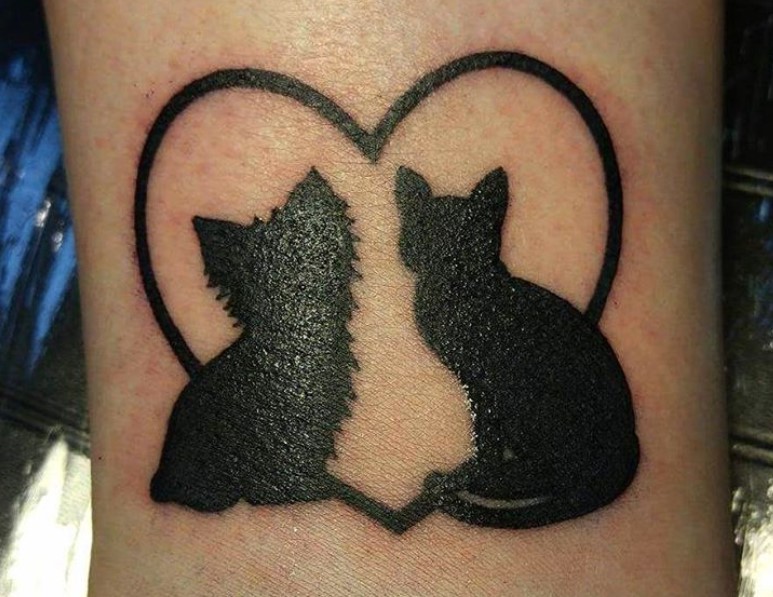 cat and dog inside a big heart tattoo on arm