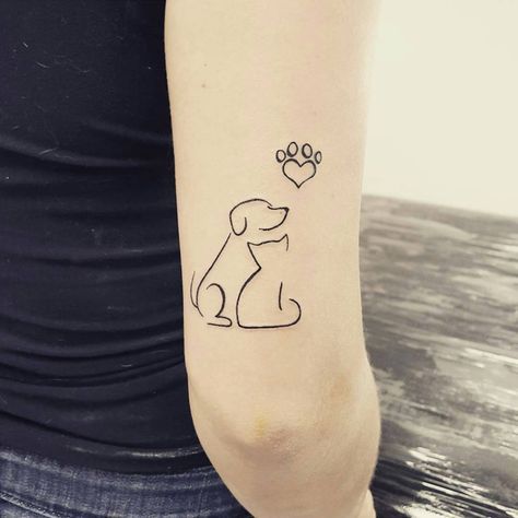 outline dog and cat with heart paw on top tattoo on the arm