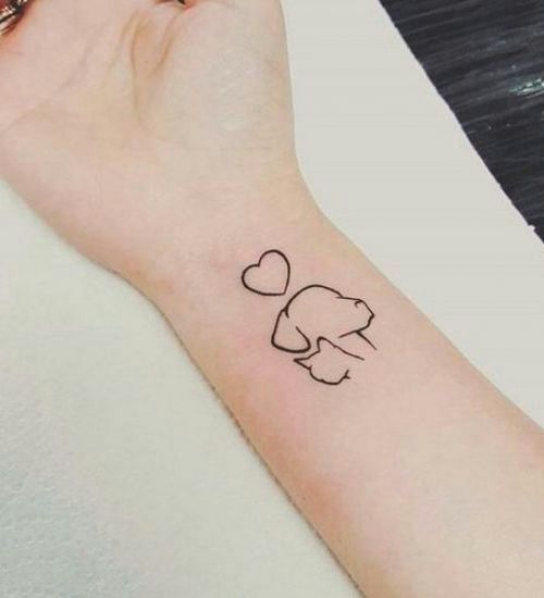 outline faces of dog and cat tattoo on the wrist